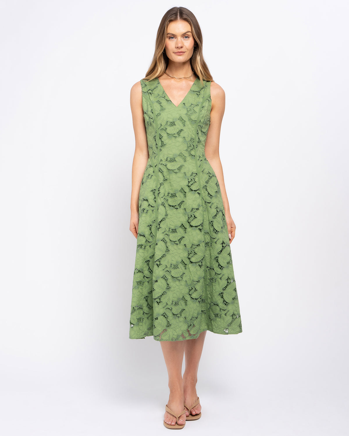 Stella Women's Sara Midi Dress - Green. A woman modeling a sleeveless V-neck midi dress in sage green with a black abstract pattern, standing against a plain white studio background.