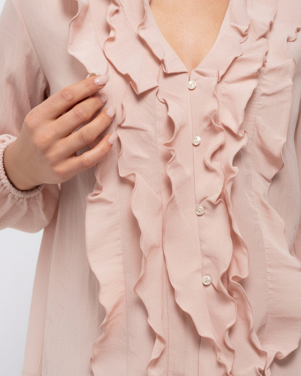 Close-up of the ruffle trim and pearl button detail on the Khloe Top in Ballerina pink